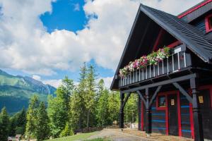 ein rotes und schwarzes Gebäude mit Blumen im Fenster in der Unterkunft Chalupa Chalet Strachan in Ždiar