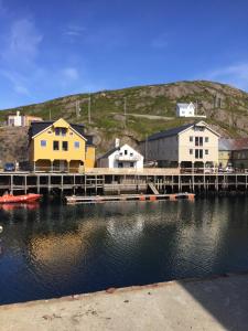 a marina with houses and a dock in the water at Lovely 3 rooms apartment for holiday in Nyksund in Nyksund