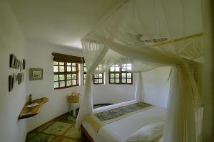 a bedroom with a bed with a canopy at Bungalow Tucul in Vilanculos
