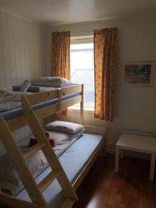 a bedroom with two bunk beds and a window at Lovely 3 rooms apartment for holiday in Nyksund in Nyksund