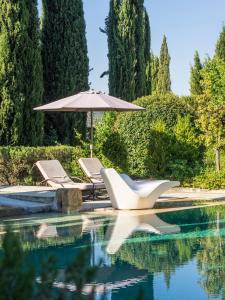 a pool with two lounge chairs and an umbrella at B&B Contemporain Le Jardin in Vaison-la-Romaine