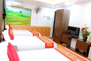 a hotel room with two beds and a tv at Xuan Hoa Hotel in Ninh Binh