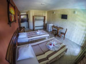 A bed or beds in a room at Hotel e Pousada Tropical Wind do Cumbuco