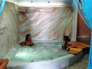 
a man and a woman sitting in a tub at Castelo Beach Hotel in Panteli
