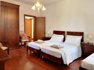 a bedroom with two beds with white sheets and wooden floors at Centro Cardinal Urbani in Zelarino