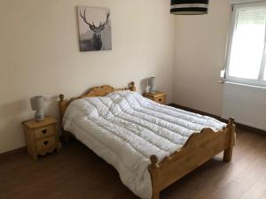 a bedroom with a bed and a deer picture on the wall at LE CANT DE JUME in Gérardmer