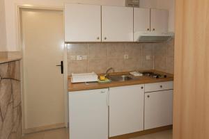 a kitchen with white cabinets and a sink at Villa Victoria in Brela