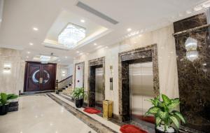 eine Lobby mit einer Treppe und einer Tür mit Pflanzen in der Unterkunft Khách sạn Hoàng Thái in Sầm Sơn