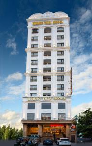 un gran edificio blanco con un cartel de hotel en Khách sạn Hoàng Thái en Sầm Sơn