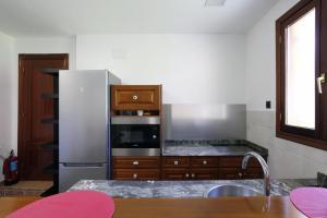 a kitchen with a stainless steel refrigerator and wooden cabinets at Castro Eco 10 in Castro-Urdiales +12 photos
