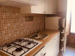 a kitchen with a stove and a sink at Bilocale in centro con giardino in Tagliacozzo