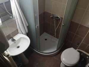 un bagno con doccia, WC e lavandino di Hotel Delta a Pljevlja