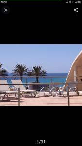 una imagen de una playa con palmeras y el océano en Villa AMALIA, en Costa Calma