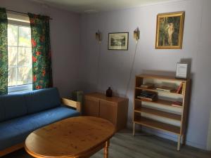 sala de estar con sofá azul y mesa en Holiday in the former fishing factory Arntzen-brygga, en Nyksund
