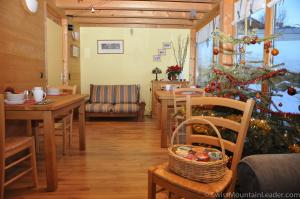 ein Wohnzimmer mit einem Weihnachtsbaum, einem Tisch und Stühlen in der Unterkunft Bed & Breakfast l'Epicéa in Leysin