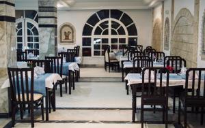 Dar El Manara Djerba Hotel & Aparts في حومة السوق: غرفة طعام مع طاولات وكراسي في غرفة