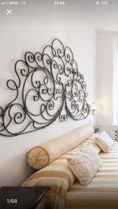 a large metal wall art above a bed at Il Tenore d'Oro Centralissimo in Parma