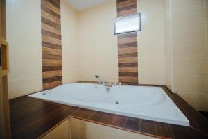 uma grande banheira na casa de banho com uma janela em Iyara Hua Hin Lodge em Hua Hin