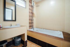 a bathroom with a tub and a sink at Iyara Hua Hin Lodge in Hua Hin