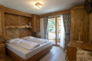 um quarto com uma cama e uma grande janela em Sport Hotel Rudolf em Gressoney-Saint-Jean