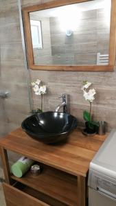 a black sink on a wooden counter in a bathroom at DOUX COCON DE 50 m2 PARIS-LE RAINCY in Le Raincy