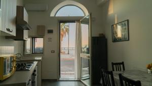 a kitchen with an open door to a patio at Il Nido del Gabbiano in Bagheria