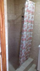 una ducha con cortina de ducha con flores en Vila Hipo en Venus
