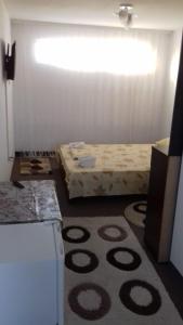 ヴィーナスにあるVila Hipoのベッドとラグ付きの小さな部屋です。