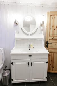 a white bathroom with a sink and a mirror at Langlofonna in Stranda