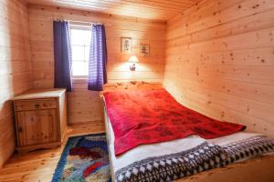 ein Schlafzimmer mit einem Bett in einem Blockhaus in der Unterkunft Langlofonna in Stranda