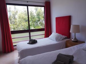 two beds in a room with a large window at Mare Viva Beach Apartment in Quarteira