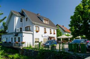 ein weißes Haus mit davor geparkt in der Unterkunft Gästehaus Cafe Andrea in Köflach