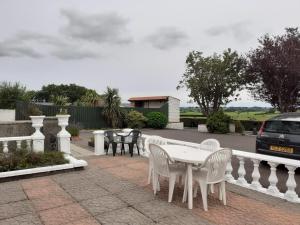 a white table and chairs on a brick patio at Gortin Glen Guest House in Garvagh