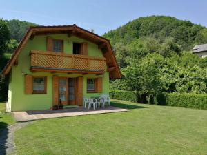 a house with a table and chairs in the yard at Chata Baračka in Omšenie