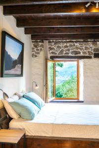 sypialnia z dużym łóżkiem i oknem w obiekcie B&B MaisonNel w mieście Saint-Bonnet-en-Champsaur