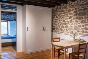 a dining room with a table and a stone wall at B&B MaisonNel in Saint-Bonnet-en-Champsaur