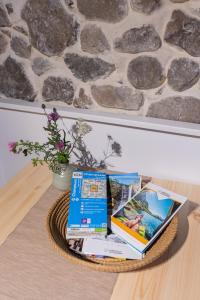 a basket with books on a table with a stone wall at B&B MaisonNel in Saint-Bonnet-en-Champsaur