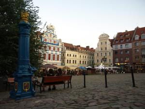 grupa ludzi siedzących na ławce obok słupa świetlnego w obiekcie Bulwary Apartments w Szczecinie