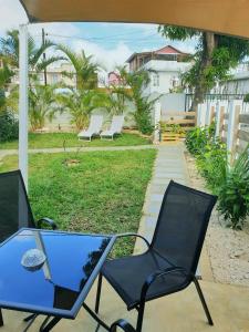 - un ensemble de chaises et d'une table sur une terrasse dans l'établissement Casa Frangipani Mauritius, à Trou dʼ Eau Douce