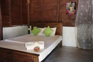 a bedroom with a bed with green and white pillows at Sun Wind Beach Kalpitiya Kite Resort in Kalpitiya