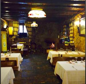 a restaurant with white tables and a fire place at La Casona in Burgos
