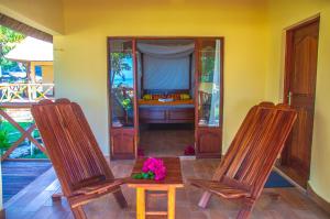two chairs and a table in a room with a bed at Vilancool Beach Resort in Vilanculos