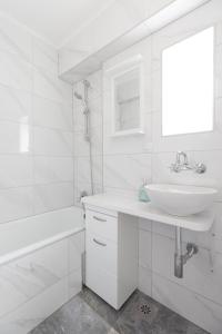 ein weißes Badezimmer mit einem Waschbecken und einer Badewanne in der Unterkunft City Center Pearl 2 in Zagreb