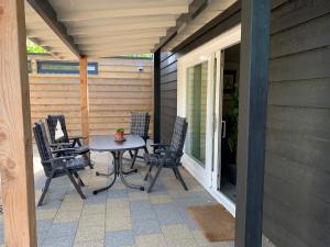 een patio met stoelen en een tafel op een veranda bij de Goede Ree Huisje 1 en 2 - No Companies in Goedereede