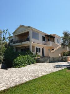 a large house with a stone driveway in front of it at Angela apartments in Lefkada Town