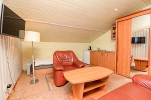 a living room with a leather chair and a table at Holiday Palanga Sea Side in Palanga