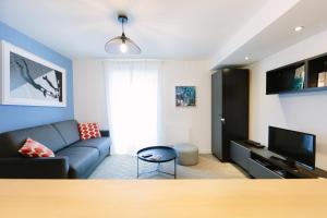 a living room with a couch and a tv at Appartistic - Appartement des artistes in Nantes