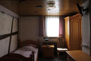 ein Schlafzimmer mit Bett, Schreibtisch und Fenster in der Unterkunft Eulenburg in Rülzheim