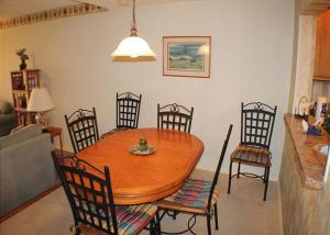 a wooden table and chairs in a room with a kitchen at Summerhouse 228 Condo in Saint Augustine