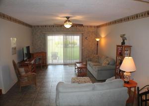 een woonkamer met een bank en een tafel bij Summerhouse 228 Condo in St. Augustine